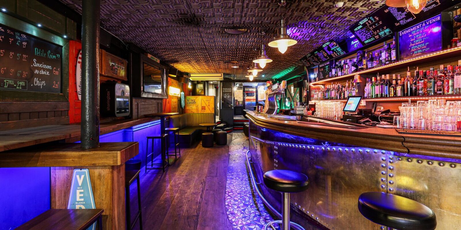 Le bar de l'IPN : comptoir cuivré éclairé en bleu, bouteilles rétroéclairées