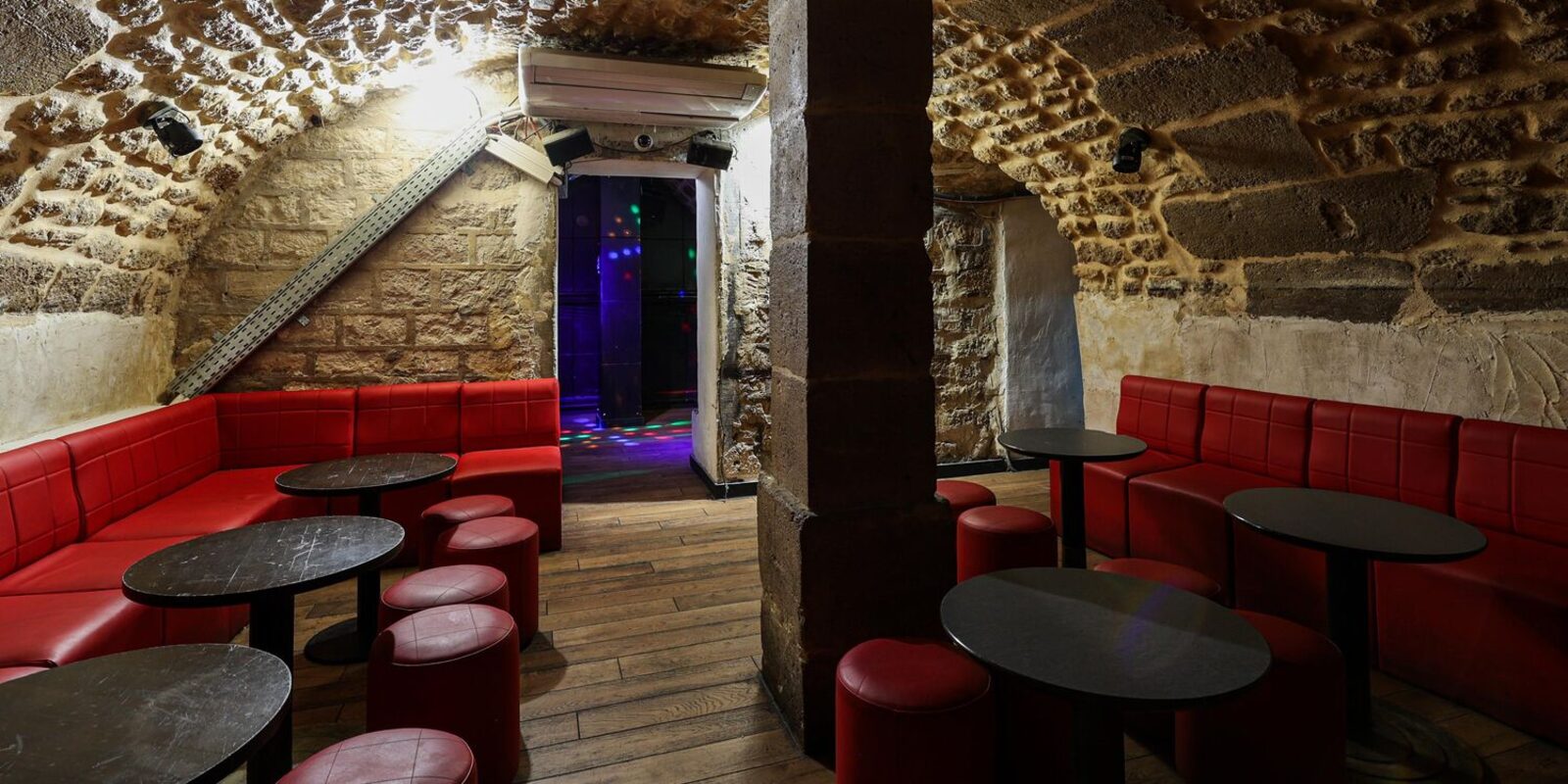 La petite cave : banquettes rouges sous la pierre