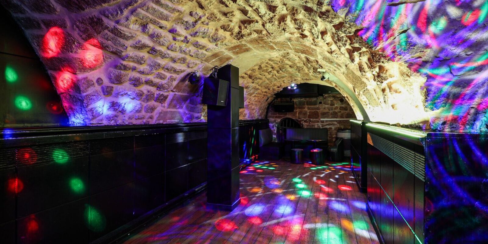 La piste de danse sous la cave voûtée, lumières disco